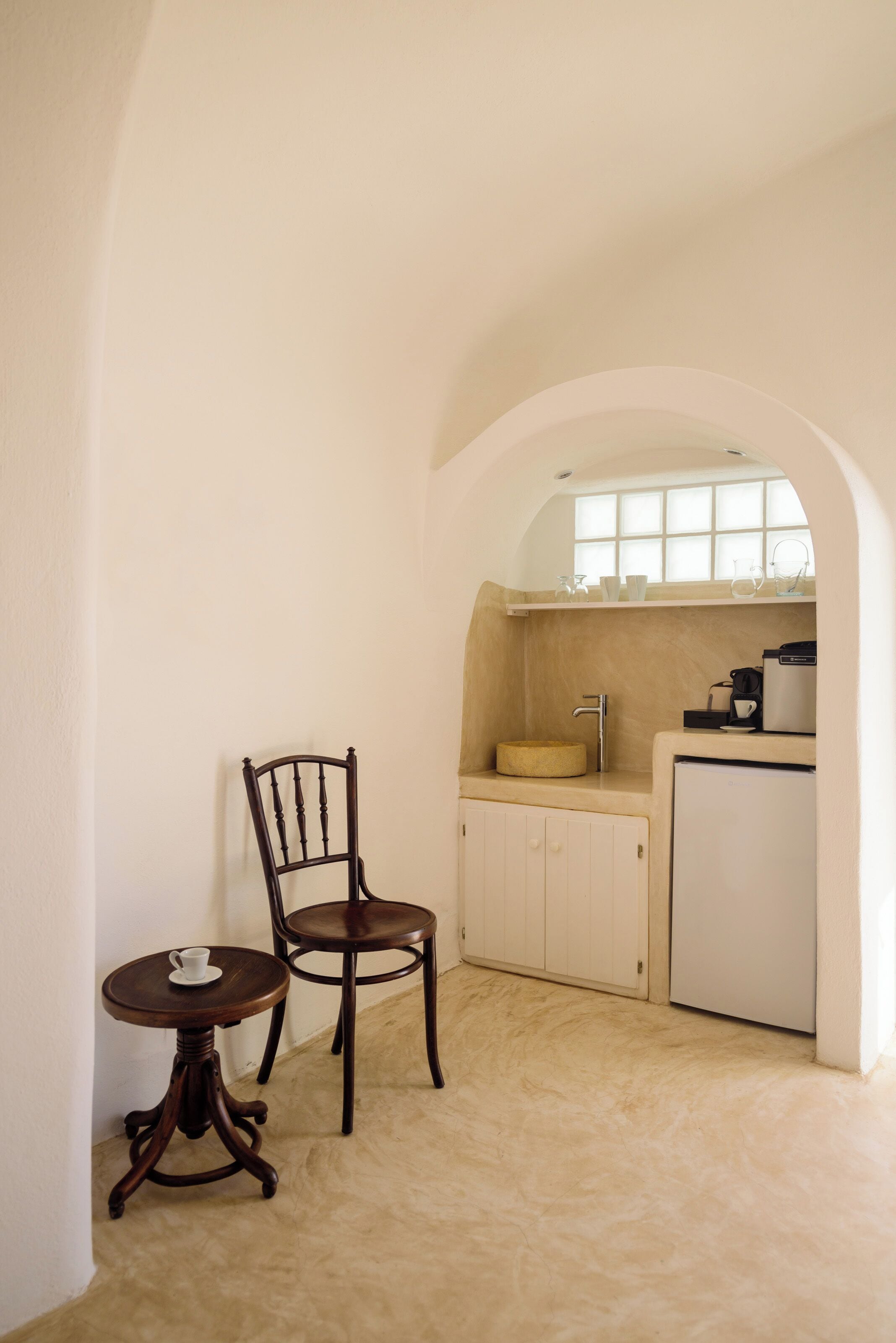 A compact kitchen with a sink, a coffee machine, and a small countertop.
