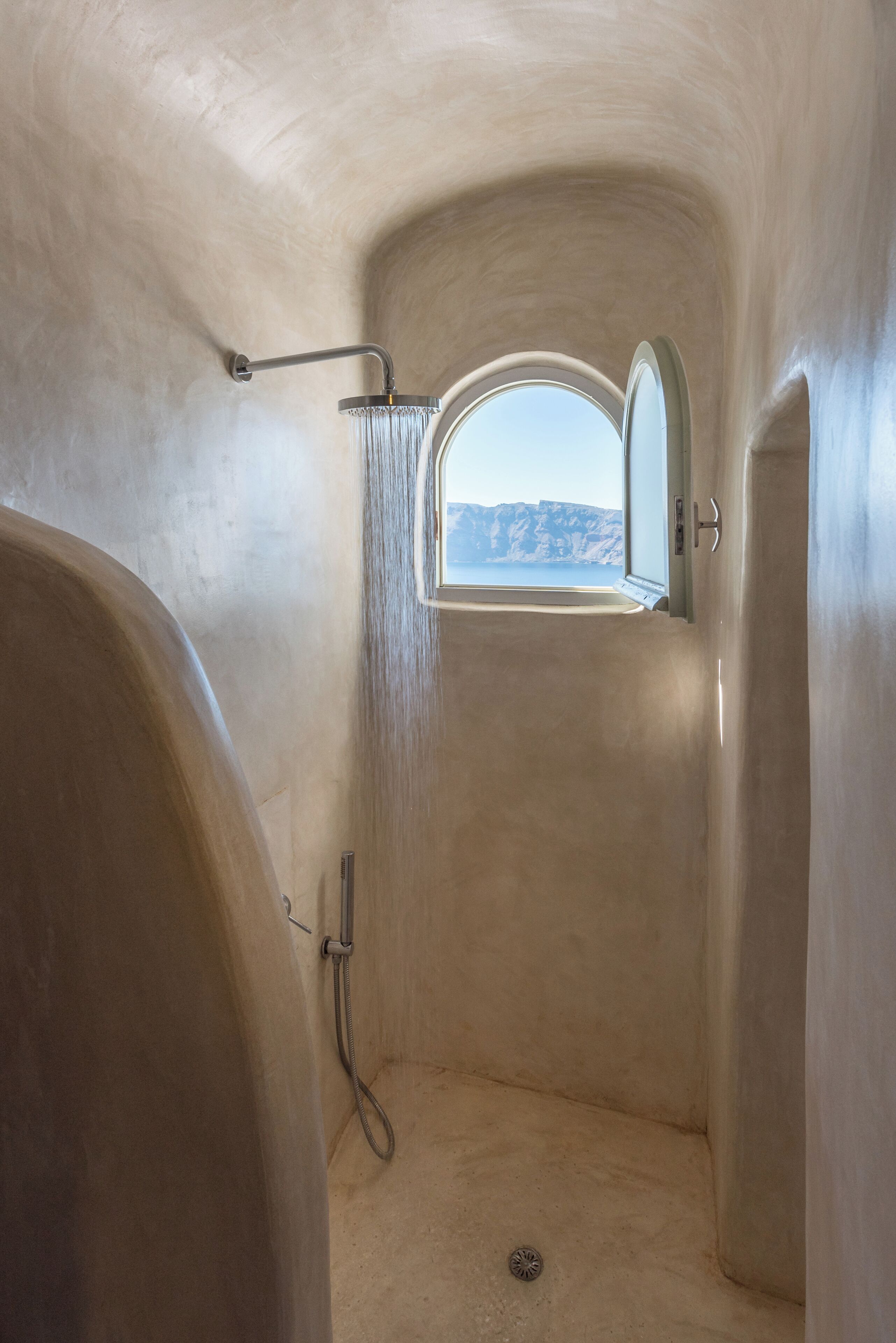 Un bagno con doccia, una finestra e vista sul mare.