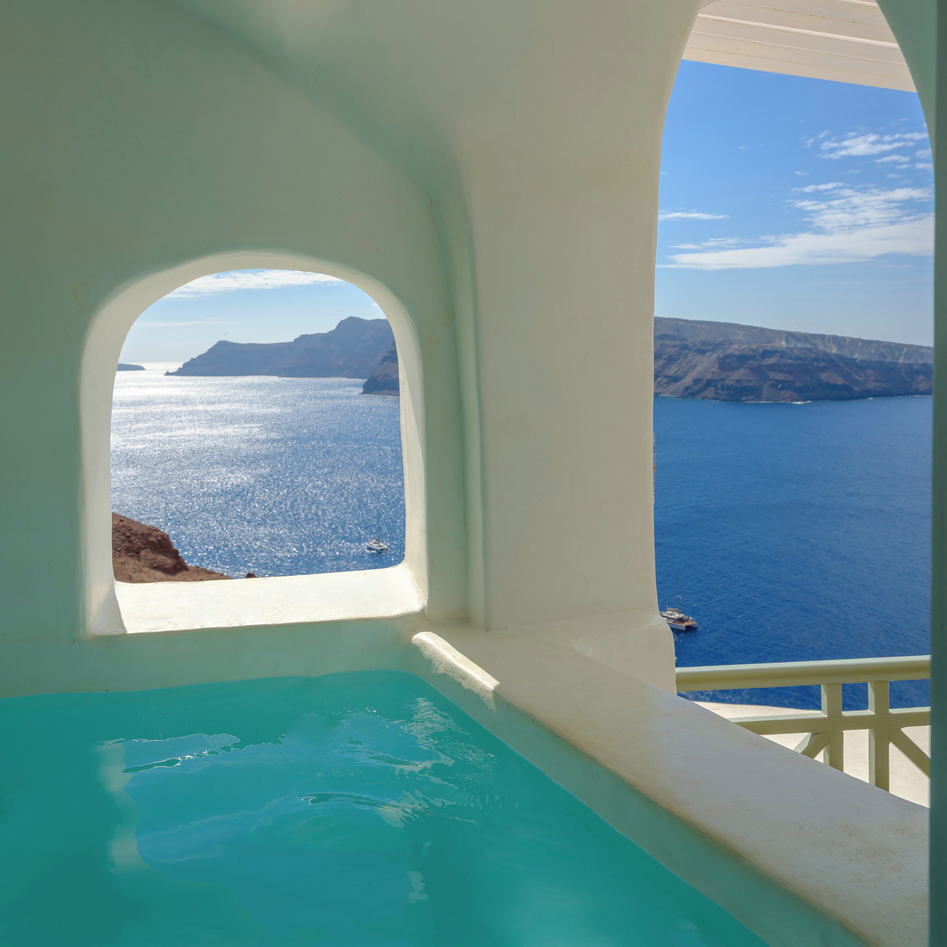 A view from a room with a window overlooking a body of water and distant landforms.