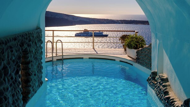 A pool with a view of the sea and a ship in the background. - Fanari Villas Santorini (Santorini)