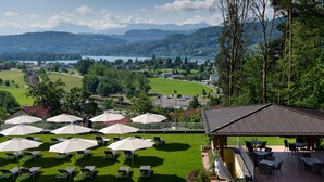Un espace extérieur aménagé avec des sièges et une vue sur un lac et des montagnes.