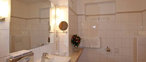 A bathroom with a sink, mirror, towel rack, and toilet.