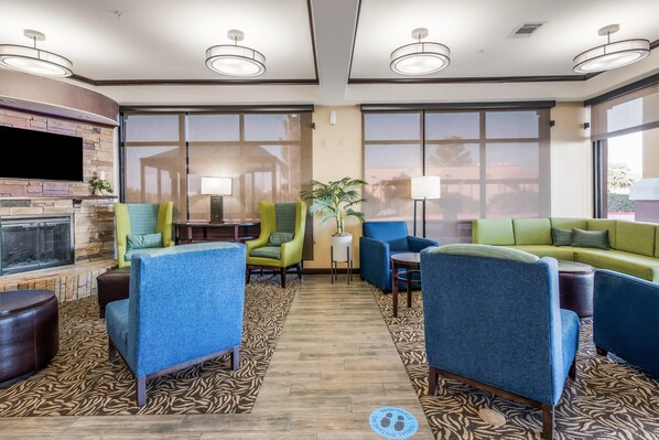 A hotel lobby with a fireplace, seating area, and large windows. - Comfort Suites Fort Stockton (Fort Stockton)