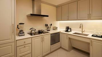 A modern kitchen with white cabinets, a built-in oven, a sink, and a stove.