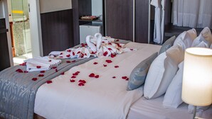 A hotel room with a neatly made bed, a bedside lamp, and a view of the bathroom and hallway. - Real Classic Hotel (Aracaju)
