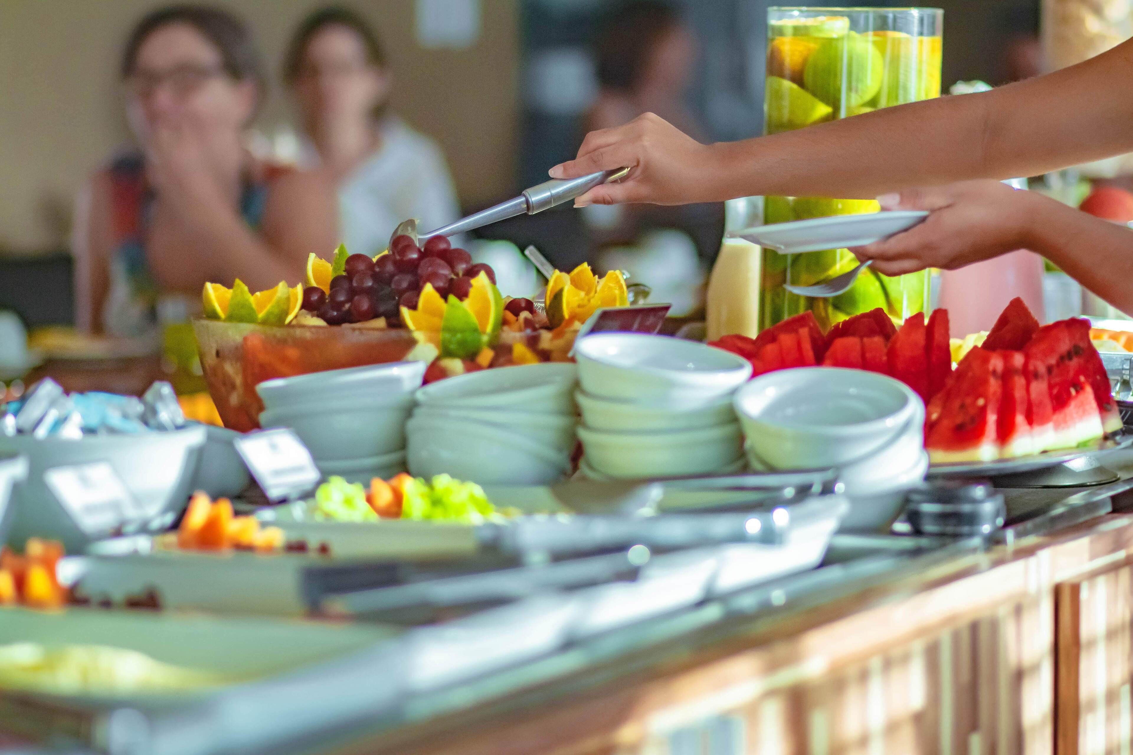 Ein Buffet mit verschiedenen Speisen und einer Person, die sich bedient.