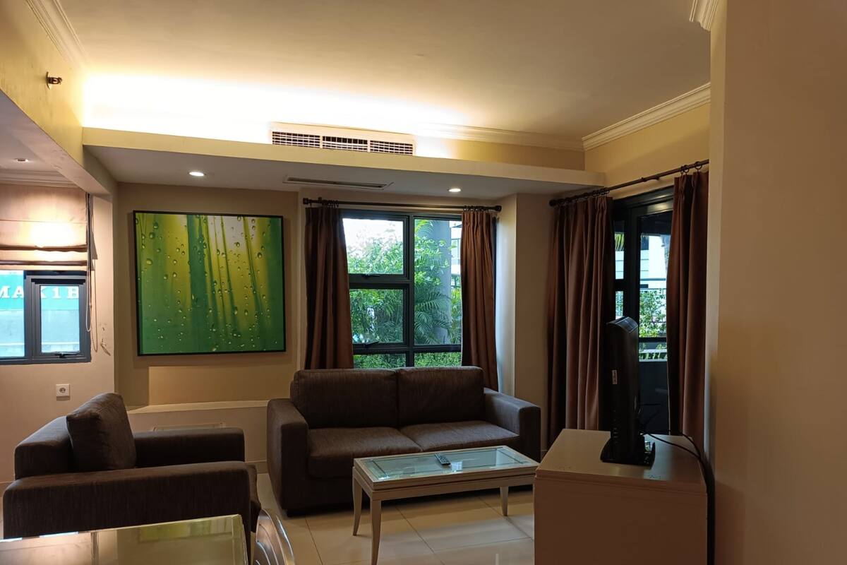 A living room with a sofa, a coffee table, and a TV.