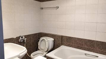 A bathroom with a toilet, bidet, and bathtub.