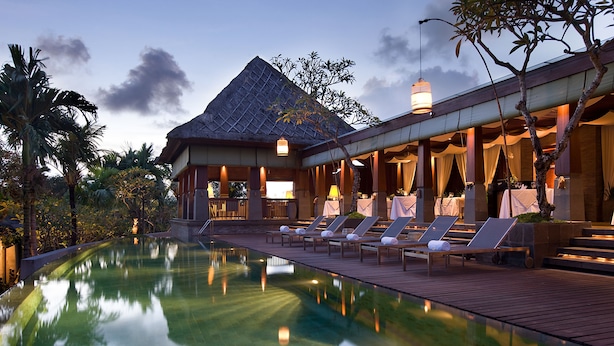 Ein Resort mit Pool, Liegestühlen und einem überdachten Essbereich.