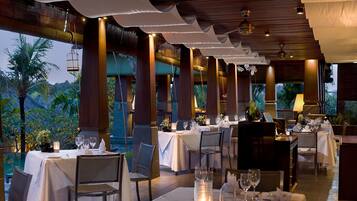 A restaurant with tables set for dining, featuring a view of the outdoors.