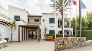 Um edifício com uma placa que diz "apts. oasis park".