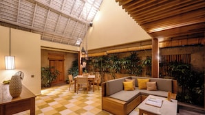 A spacious indoor area with a checkered floor, wooden furniture, and a high ceiling with natural light.