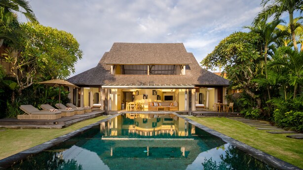 A two-story house with a swimming pool in the foreground.