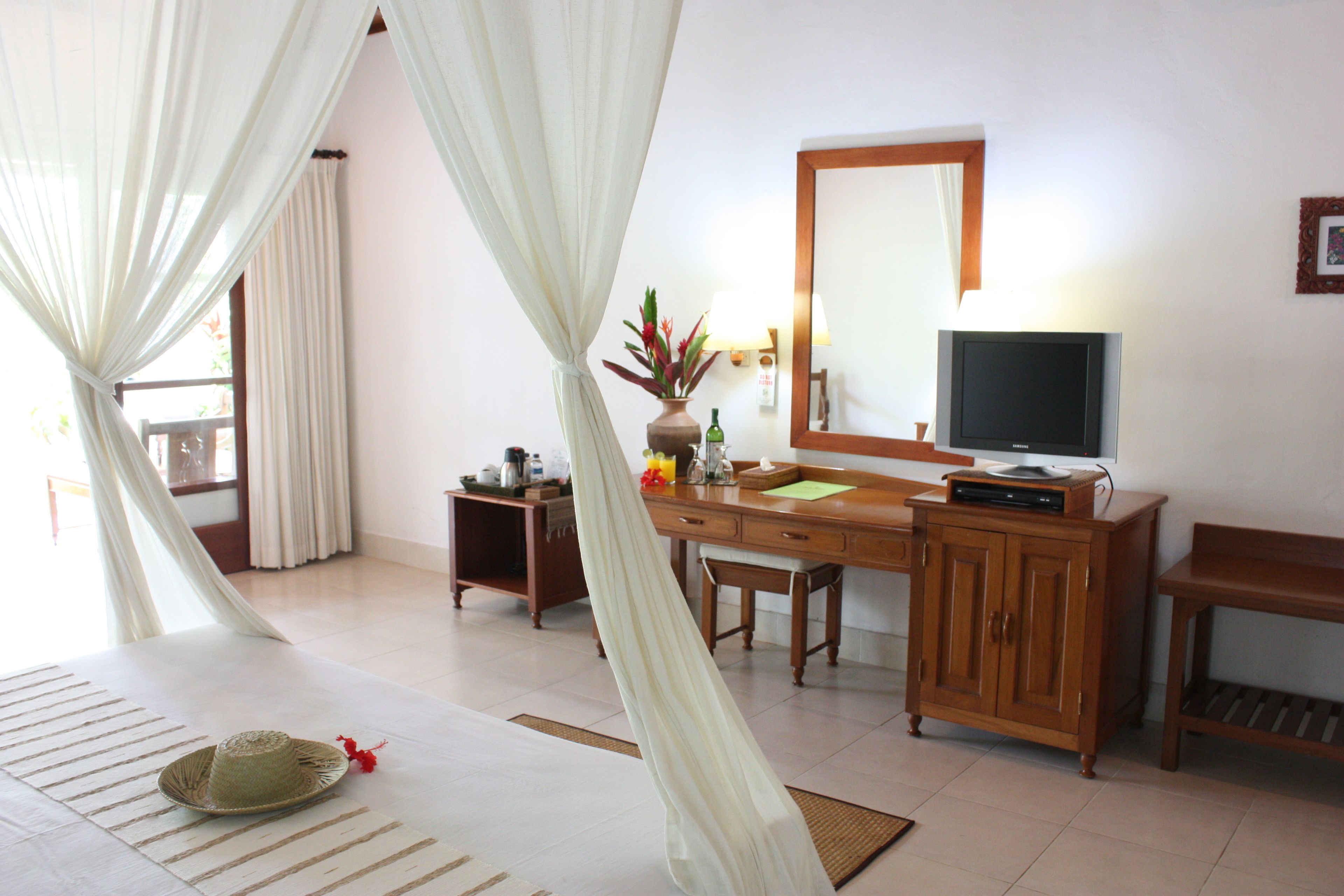 A hotel room with a bed, a desk, a television, and a cabinet.