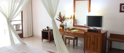 A hotel room with a bed, a desk, a television, and a cabinet.