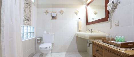 A bathroom with a toilet, sink, and vanity.
