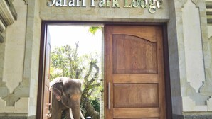 La entrada al Safari Park Lodge, con una puerta de madera y un cartel encima.