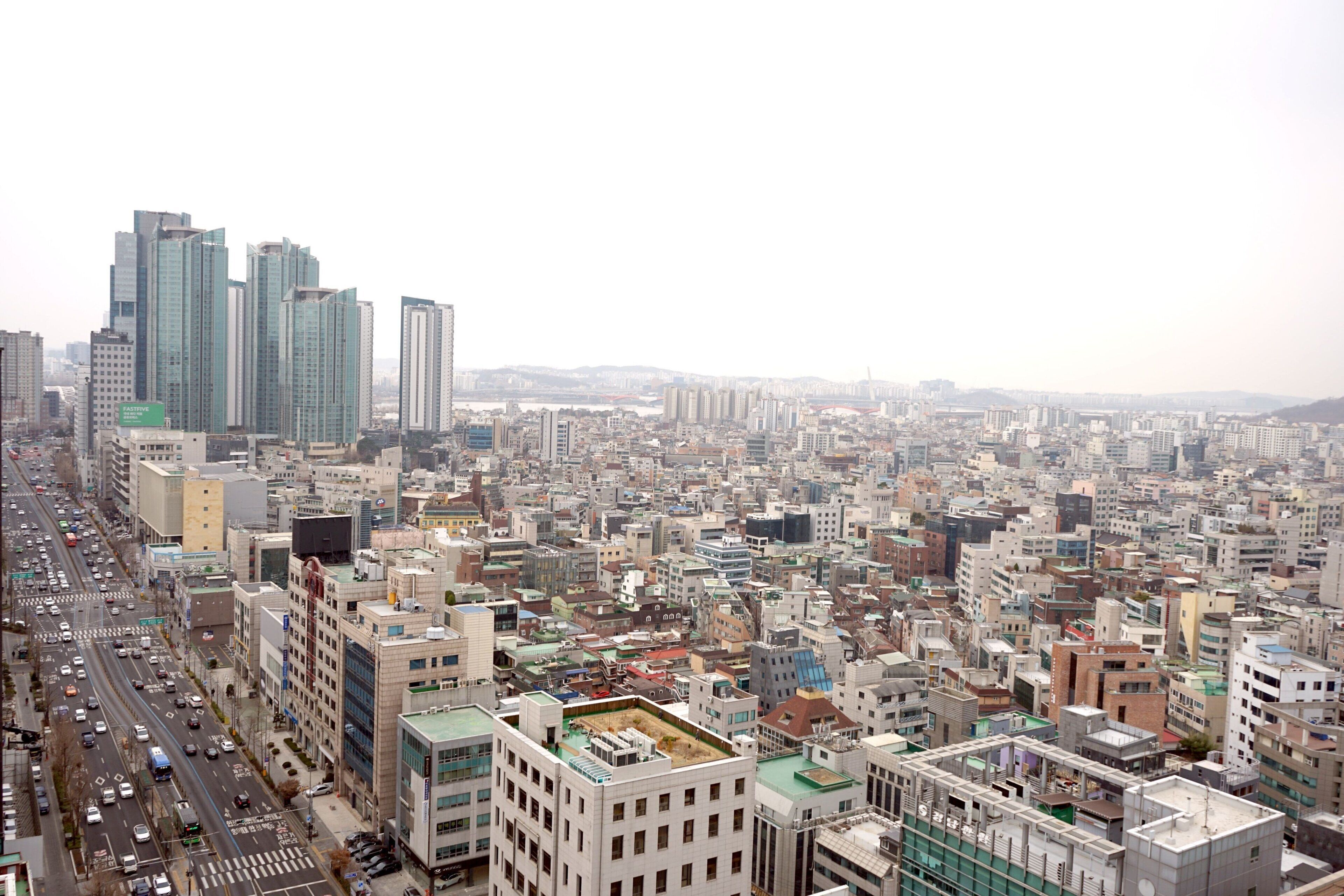 A cityscape with dense urban buildings, a busy street, and a clear sky.