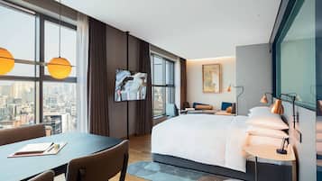 A modern hotel room with a large bed, a desk, and a TV.