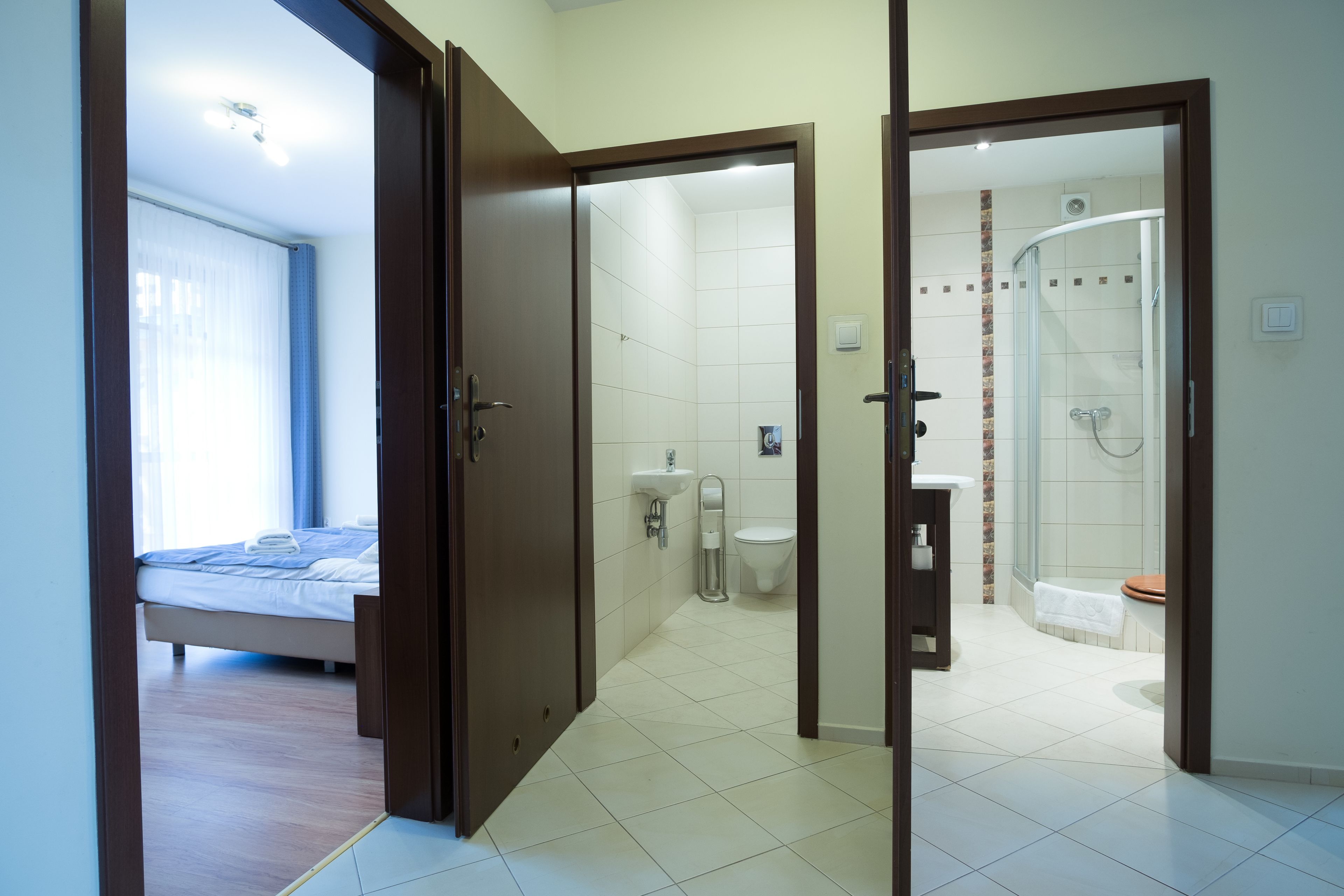Ein Hotelzimmer mit Bett, einem Badezimmer mit Dusche und Toilette.