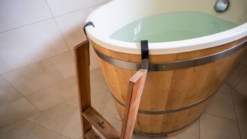 A wooden bathtub with a metal frame and a metal handle.