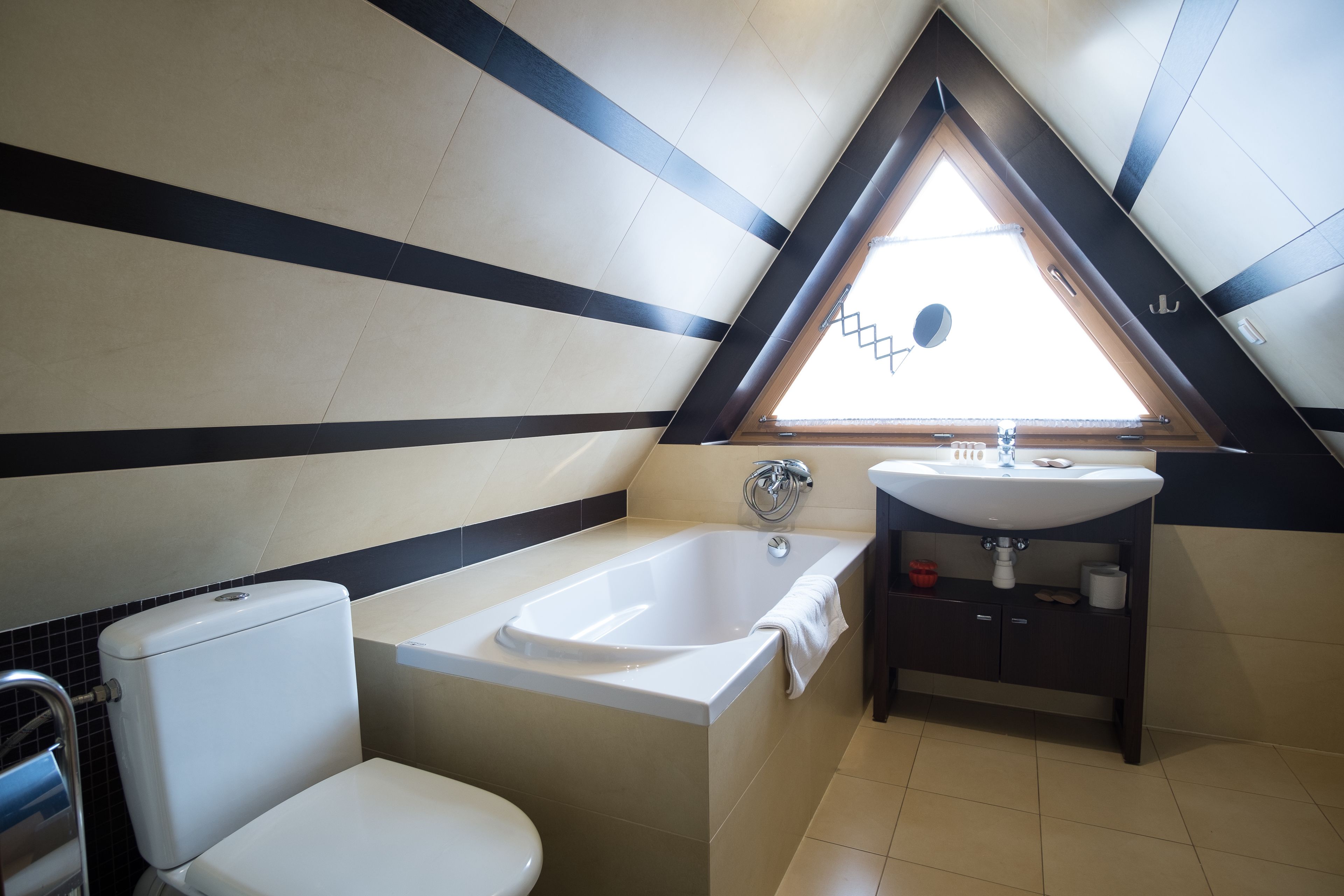Ein modernes Badezimmer mit Badewanne, Toilette und Waschbecken.