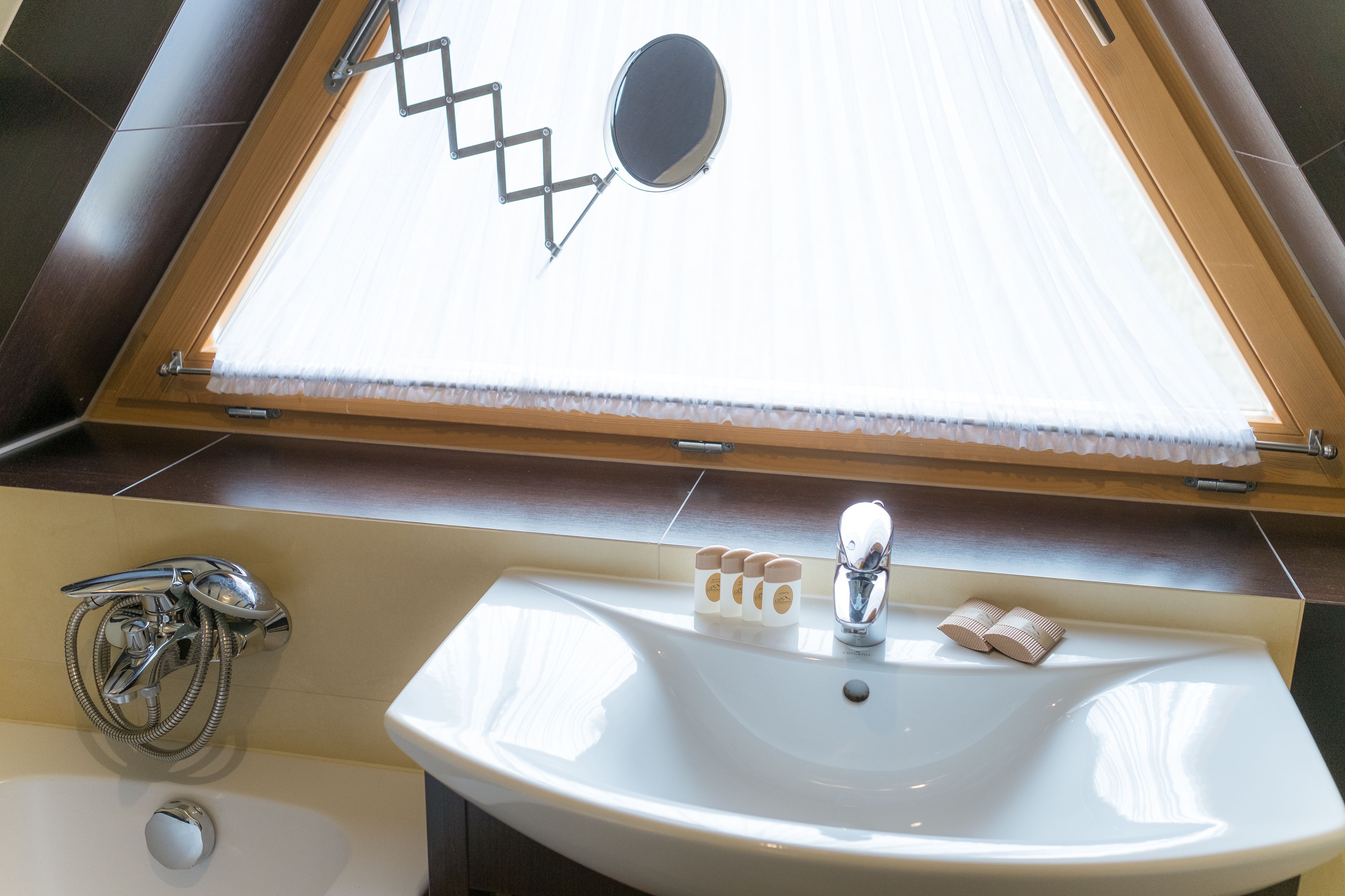 A bathroom with a skylight, a sink, and a shower.