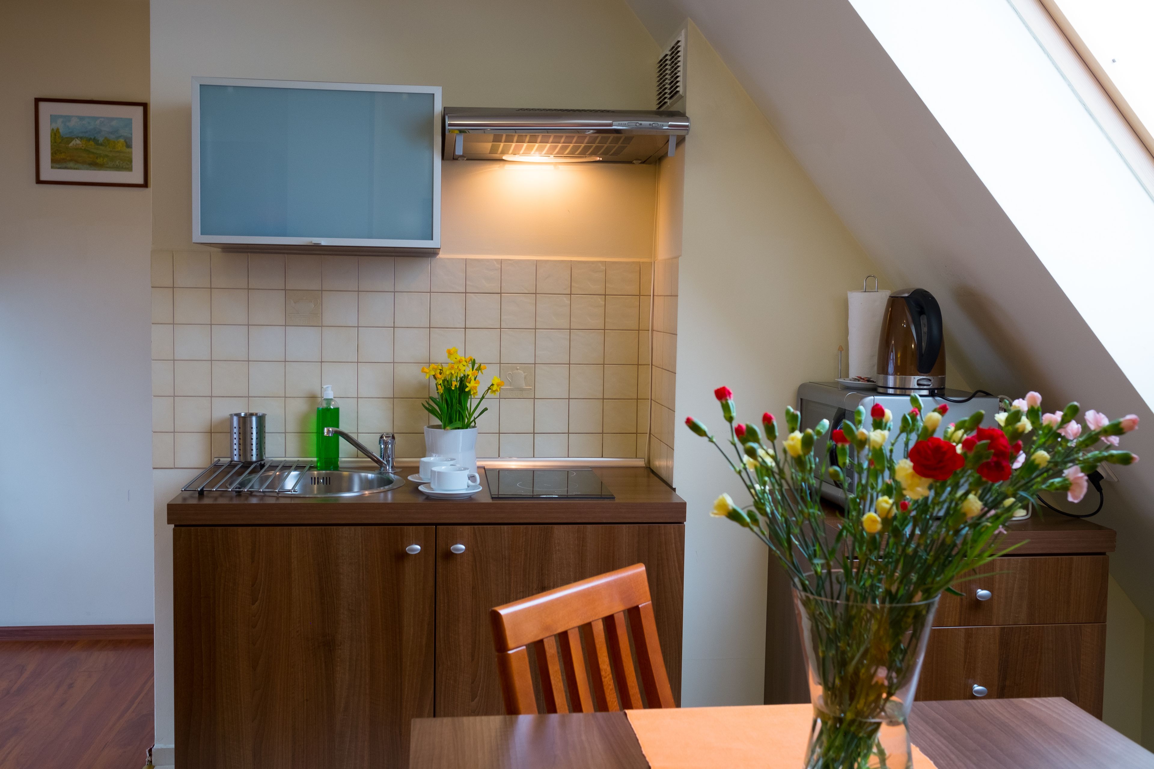 A kitchen with a wooden countertop, a sink, a stove, and a window above the stove.