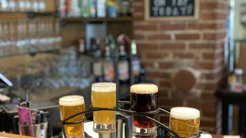 Un bar con una selección de vasos de cerveza en un porta vasos.