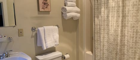 A bathroom with a sink, toilet, and shower curtain.