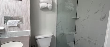Une salle de bain moderne avec un lavabo en marbre, des toilettes et une cabine de douche en verre.