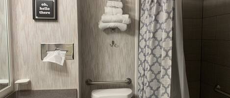 A bathroom with a sink, toilet, towel rack, and shower curtain.