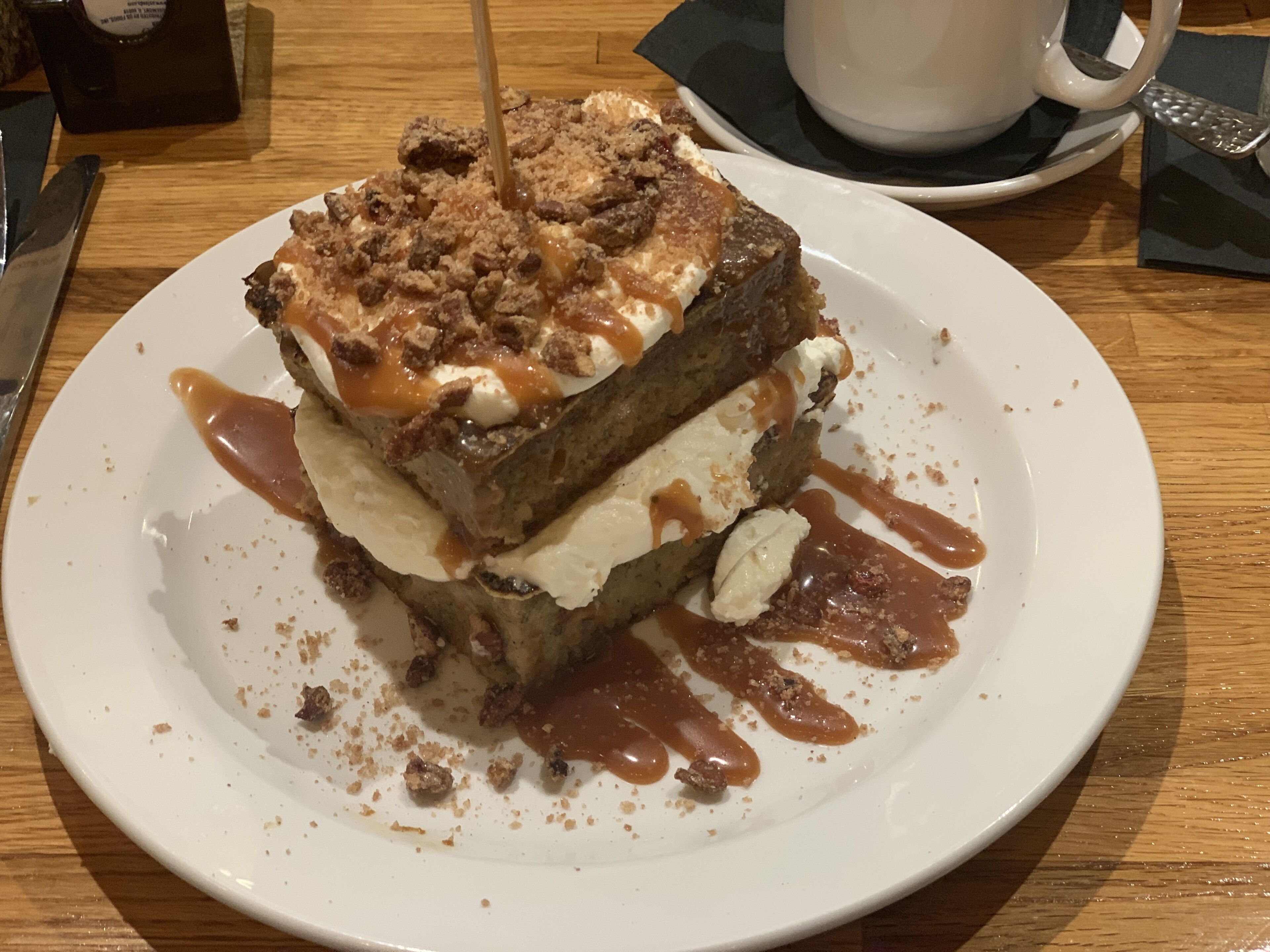 A dessert on a plate with caramel sauce and a toothpick.