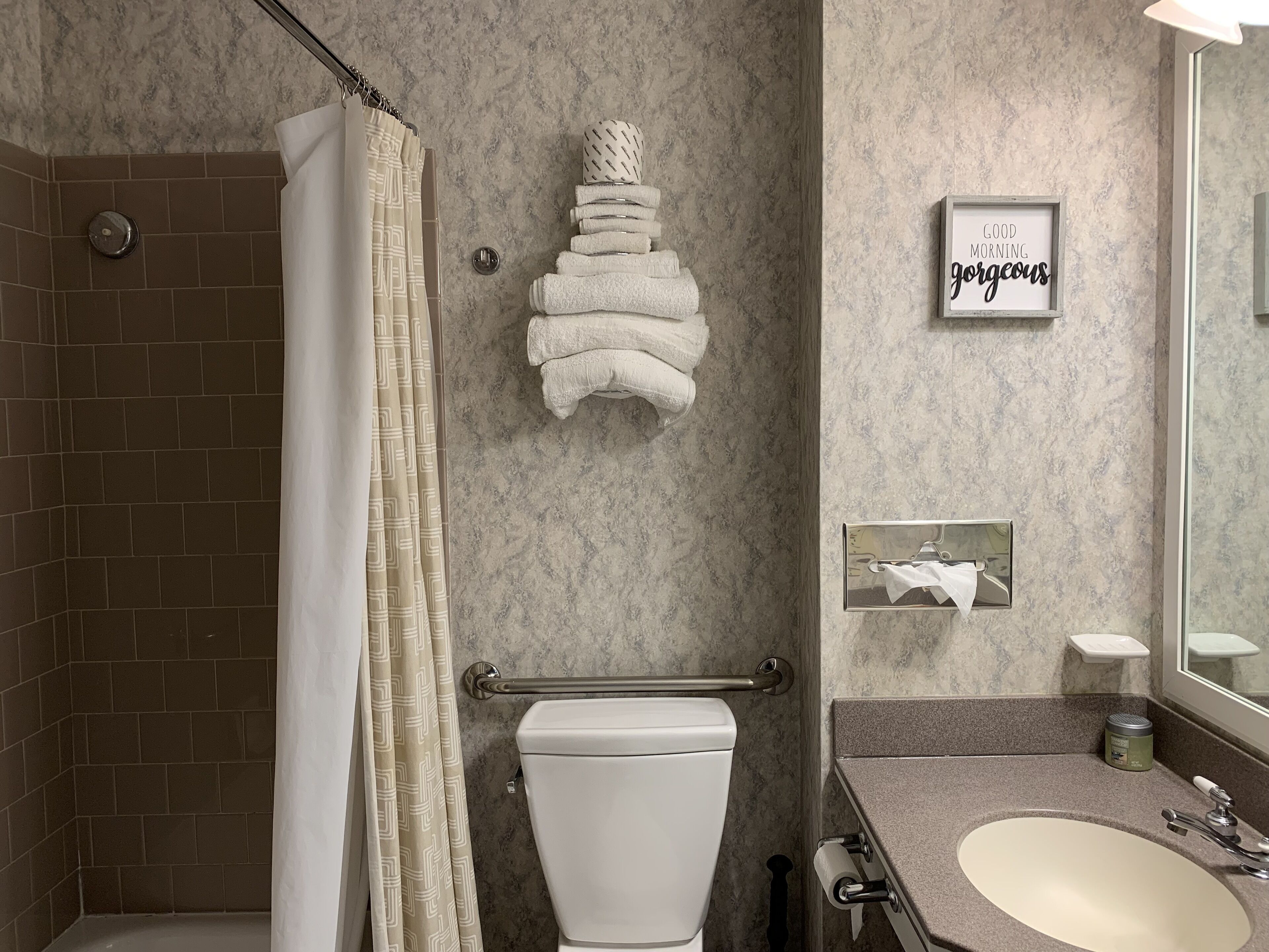Une salle de bain moderne équipée d’une douche, de toilettes et d’un lavabo.