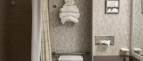 Une salle de bain moderne équipée d’une douche, de toilettes et d’un lavabo.
