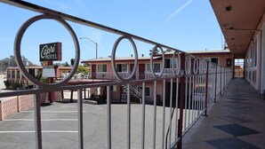 Un motel avec une enseigne indiquant « Capri Motel », un parking et une allée couverte avec des garde-corps.