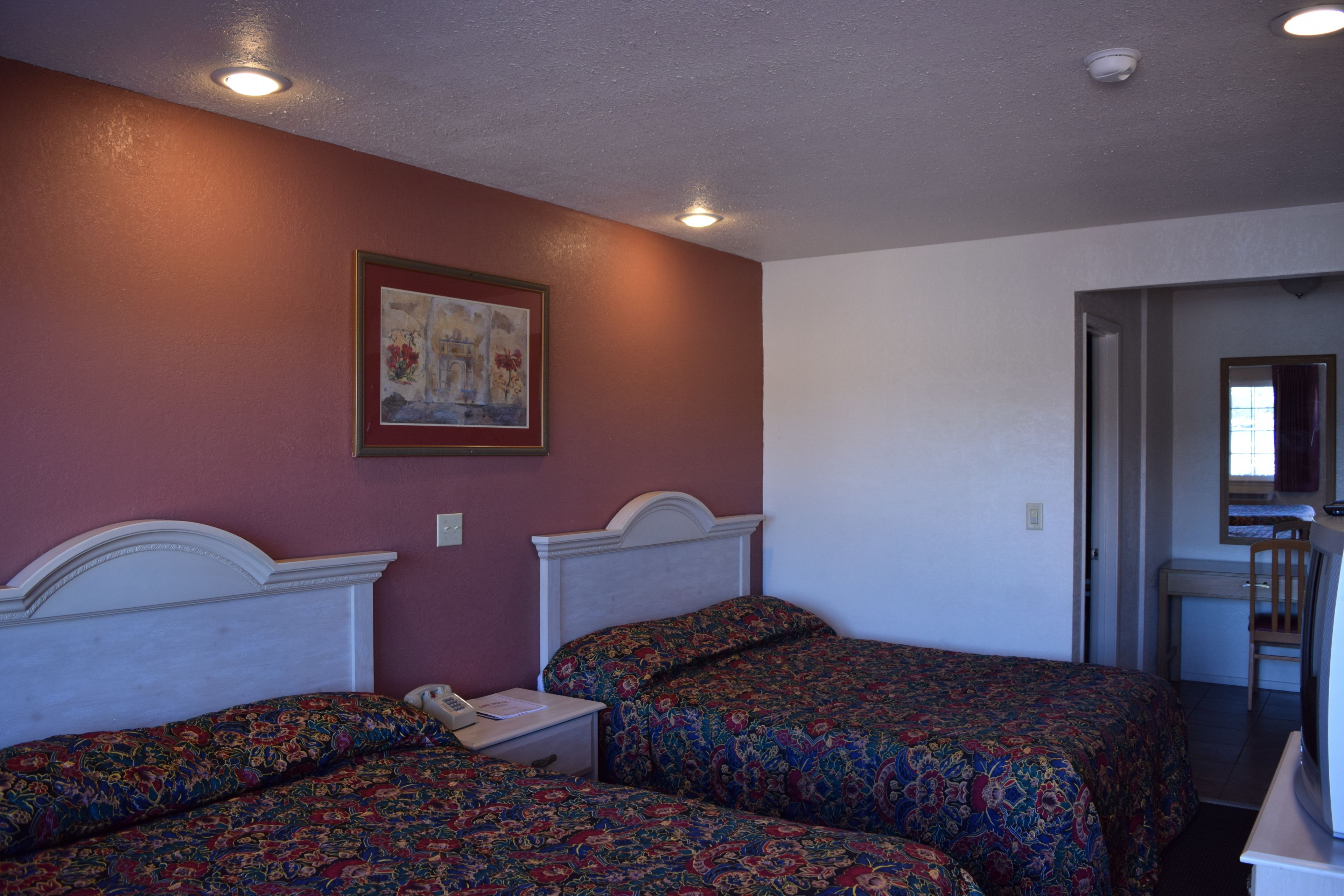 A room with two beds, a desk, and a chair.