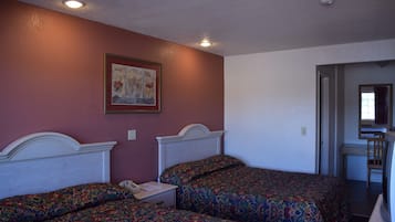 A room with two beds, a desk, and a chair.