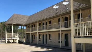 Un motel composé d’un bâtiment à deux étages, d’un espace de stationnement couvert et d’un espace extérieur clôturé.