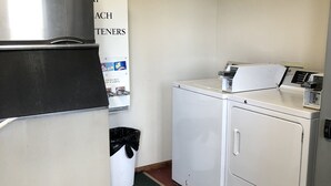 Une buanderie équipée d’un réfrigérateur en acier inoxydable, d’un lave-linge et d’un sèche-linge.