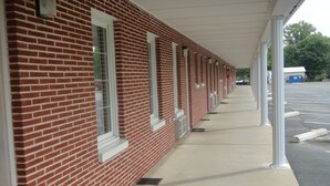 A row of red brick buildings with white window frames and a covered walkway.