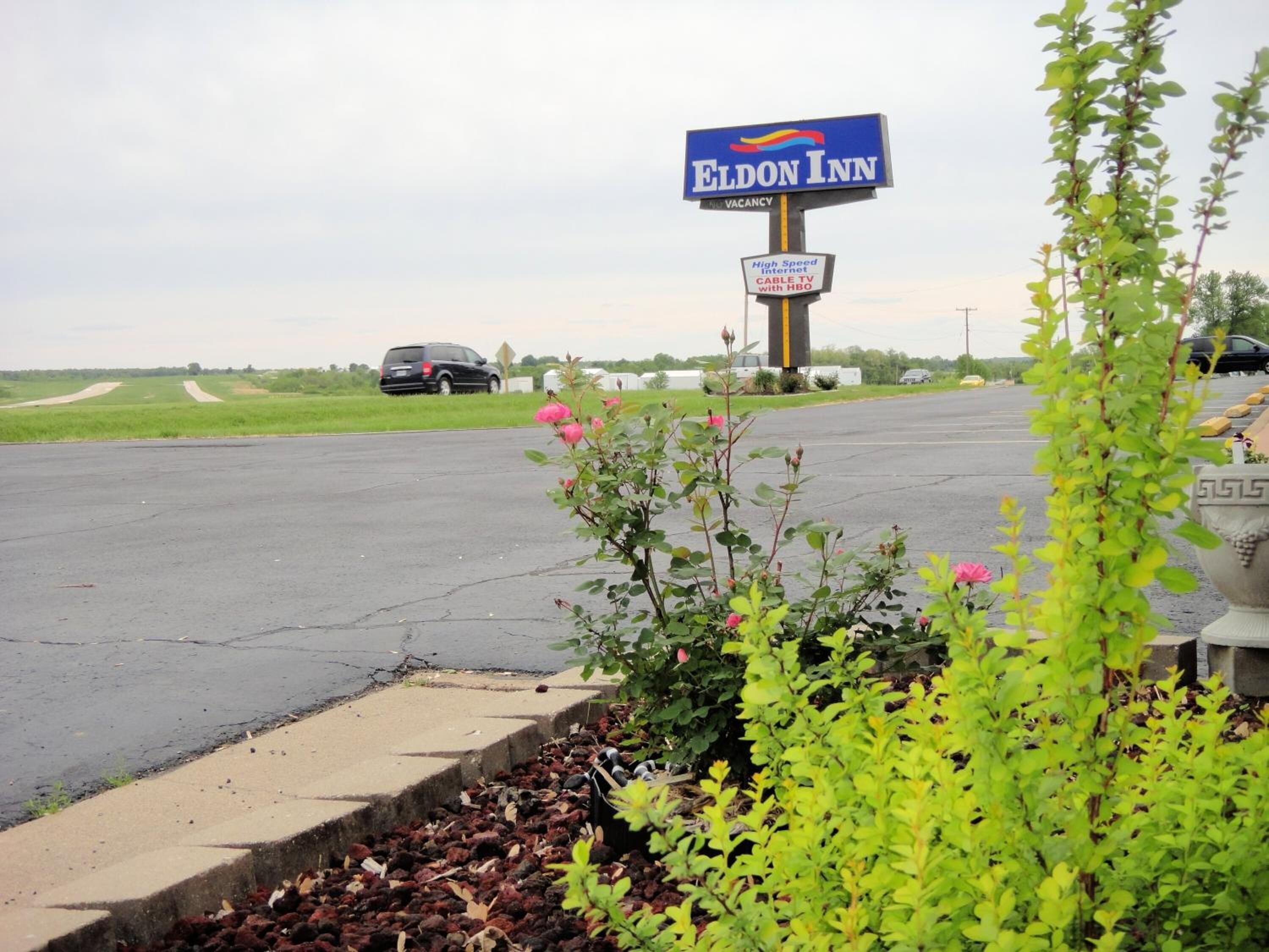 A parking lot with a sign for Eldon Inn, indicating high-speed internet and cable TV with HBO.