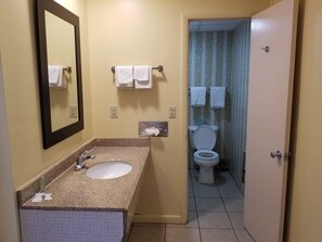 A bathroom with a sink, mirror, and two towels on a rack.