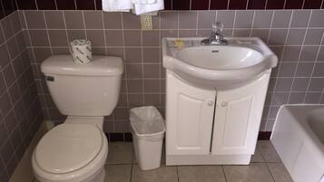 A bathroom with a toilet, sink, and trash bin.