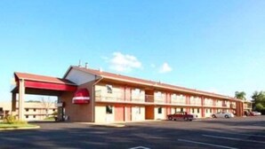 A motel with a red awning, a gas station attached, and a row of rooms. - OYO Hotel Richburg SC I-77 (Richburg)