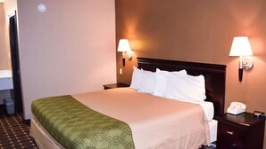 A hotel room with a bed, two bedside lamps, a nightstand with a telephone, and a door to the bathroom. - OYO Hotel Richburg SC I-77 (Richburg)