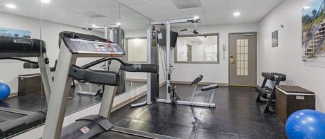 A gym with treadmills, weight machines, and exercise balls.