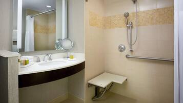 A modern bathroom with a sink, mirror, and shower.