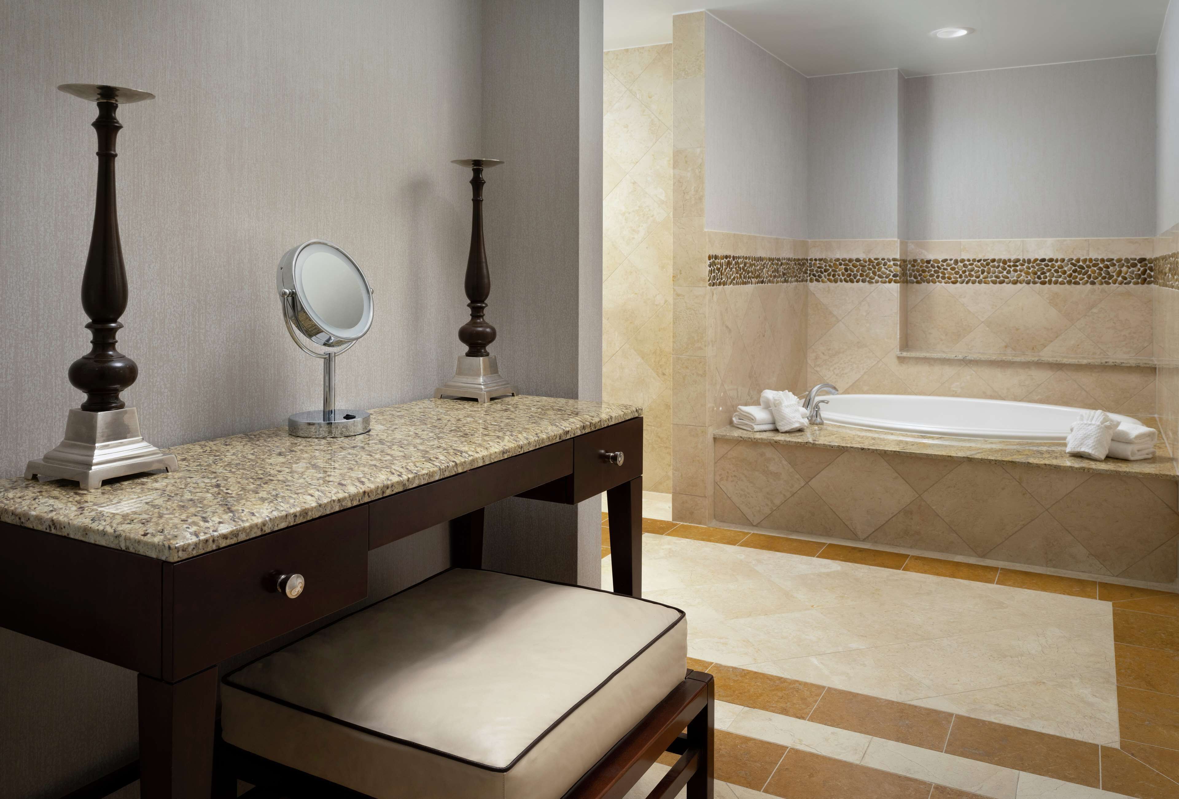 Une salle de bain comprenant un meuble-lavabo, un miroir, une baignoire et un espace douche.