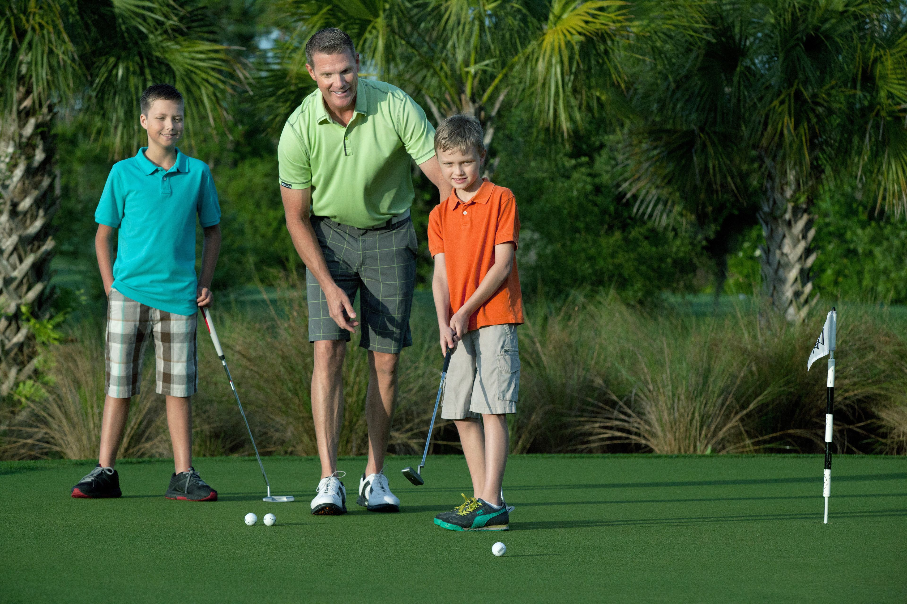 A golf course with players and a flagstick.